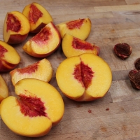 Step 2 - Cut peaches into quarters removing pits